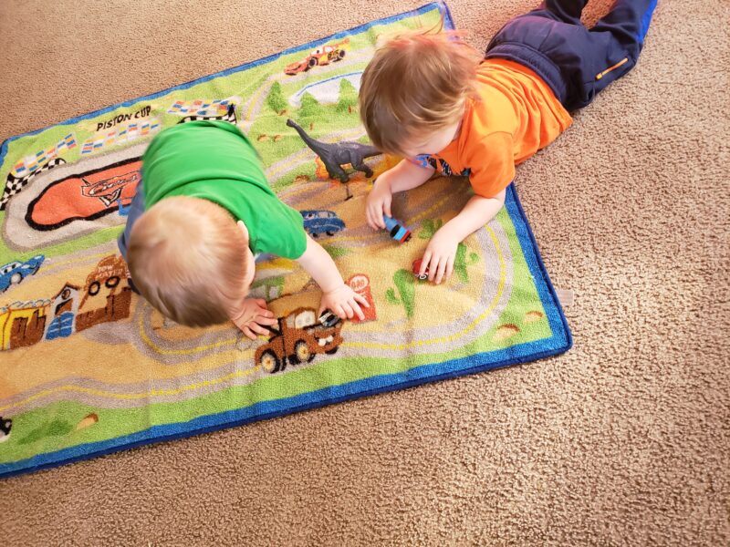 Children playing with toy cars on a rug