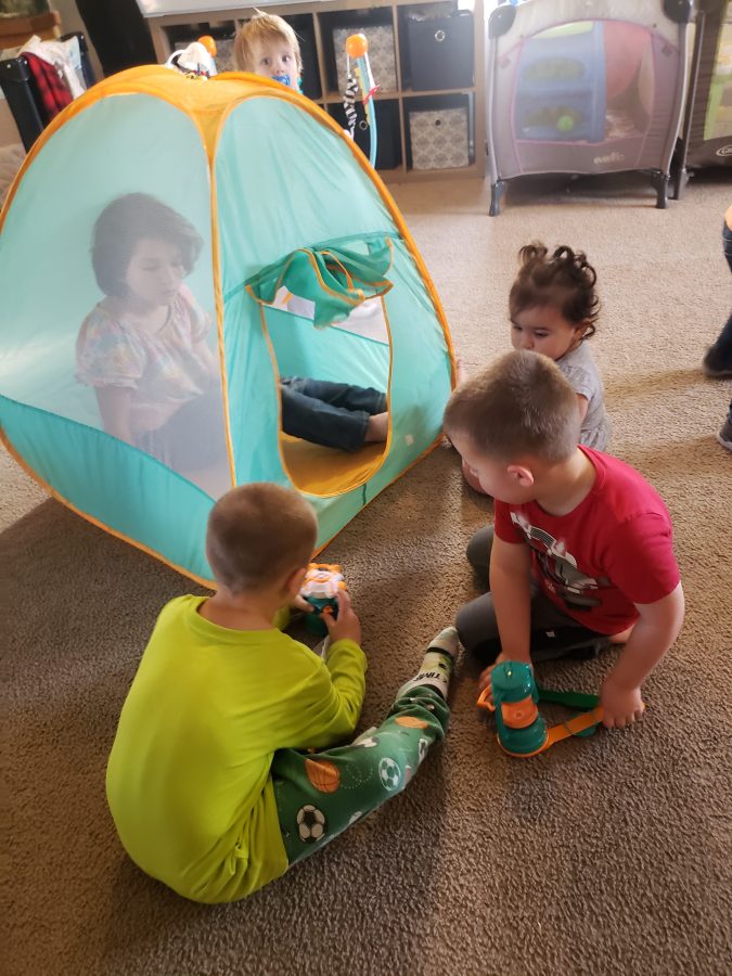 Children playing around a pop-up tent